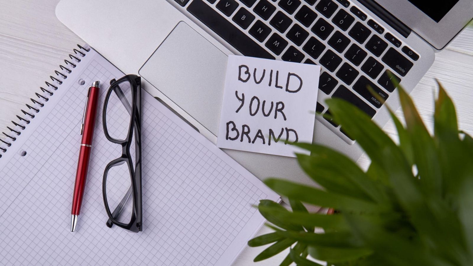 THƯƠNG HIỆU CÁ NHÂN LÀ GÌ? CÁCH XÂY DỰNG PERSONAL BRANDING BÀI BẢN VÀ BỀN VỮNG 2 Góc làm việc tối giản với ghi chú Build Your Brand và sổ tay lập kế hoạch định vị cá nhân